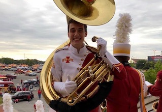 Student in band uniform, holding instrument