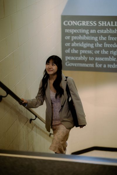 Student in stairwell with a graphic displaying the text of the First Amendment.