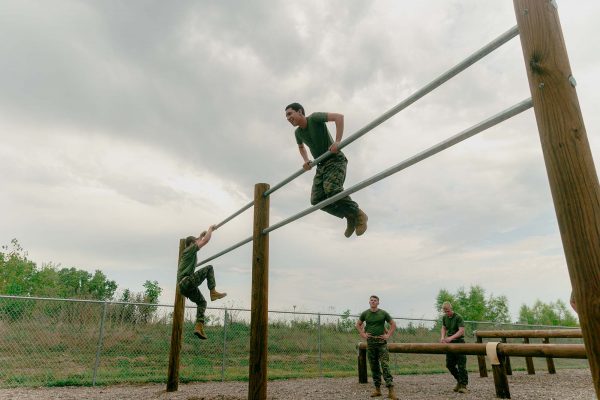 ROTC students tackle double metal bars at Iowa State's obstacle course.